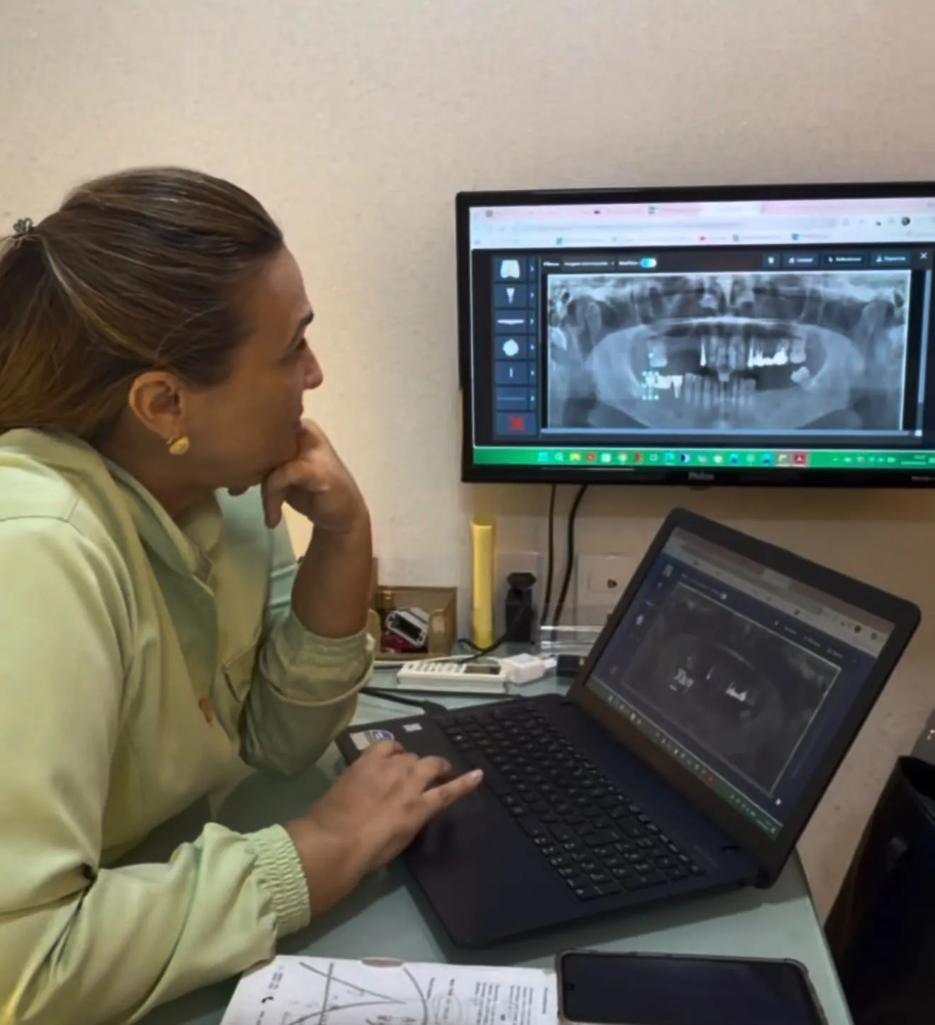 Dra. Cristiane Almeida analisando uma radiografia panorâmica em tela digital para planejar o tratamento