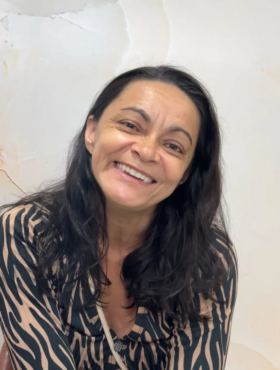 Paciente sorrindo no consultório após a conclusão do tratamento odontológico